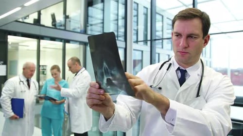 Young Adult Doctor Examines X-Ray in Hospital Setting