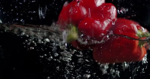 Red Bell Peppers Dropping into Water Tank