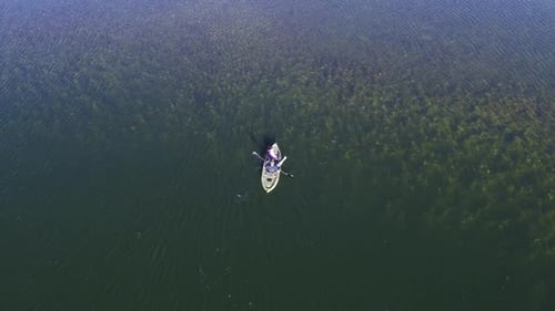 View of person paddling kayak over crystal clear water