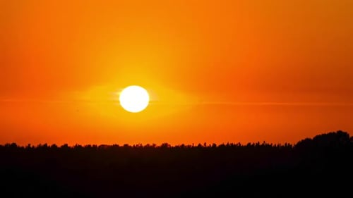 Sonnenuntergang am gelben Himmel. Zeitraffer. Die große hellgelbe Sonne bewegt sich unter.