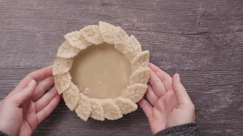 Pie Shell with Decorative Leaves on Wood Surface