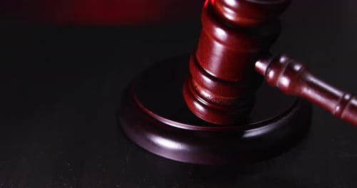 Wooden Gavel Strikes Sound Block in Spotlight