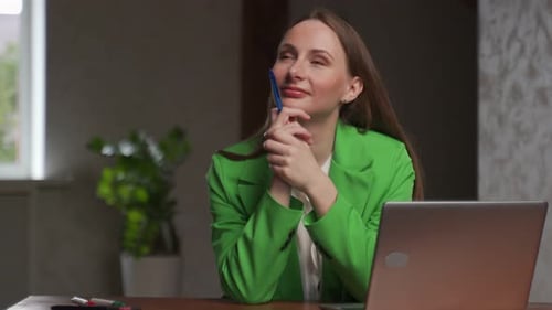 Woman Working at Desk with Laptop in Office