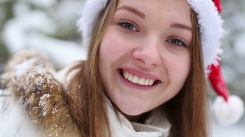 Woman in Santa Hat Smiles in Snowy Winter Scene