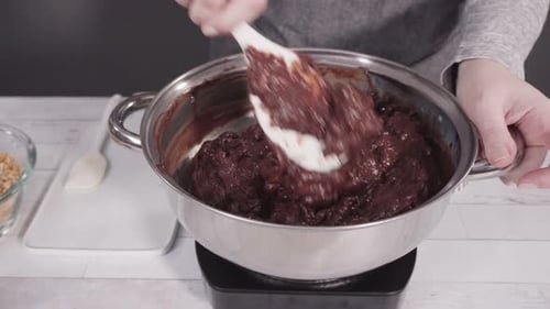 Step by step. Melting chocolate chips in the cooking pot to make macadamia nut fudge.