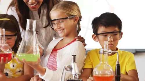 School kids doing a chemical experiment in laboratory