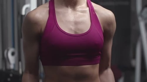 Woman Doing Bicep Curls at the Gym