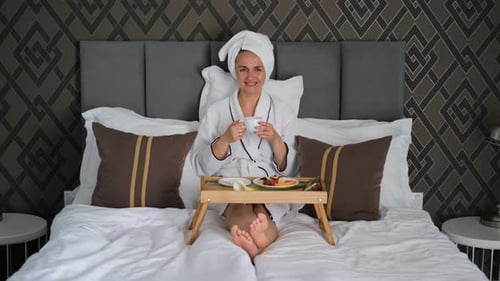 Woman Drinking Coffee and Eating Breakfast in Bed