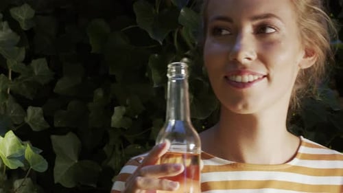 Femme buvant de la limonade devant le mur de lierre