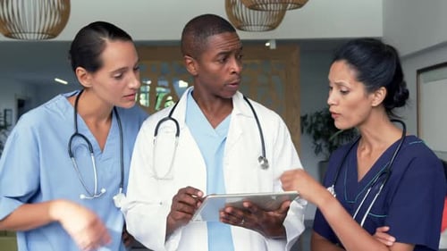 Front view of multi-ethnic doctors discussing over digital tablet in the hospital 4k