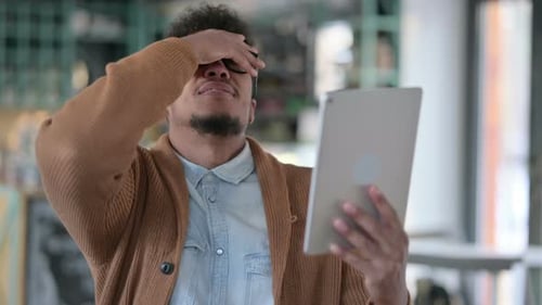 Young Adult Using Tablet Making Frustrated Expressions