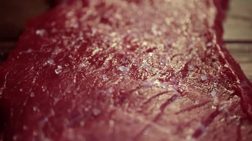 Grobes Meersalz auf dem Rohfleischsteak Nahaufnahme