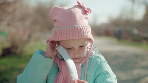Child Putting on Protective Face Mask Outdoors