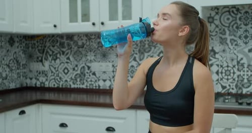 Young Woman Drinks Water After Workout