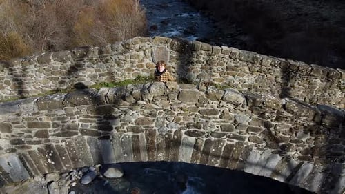 Garçon joyeux jouant sur le vieux pont dans la vallée de la forêt