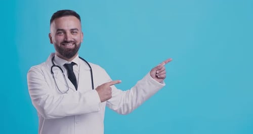 Smiling Doctor Points to Area on Blue Background