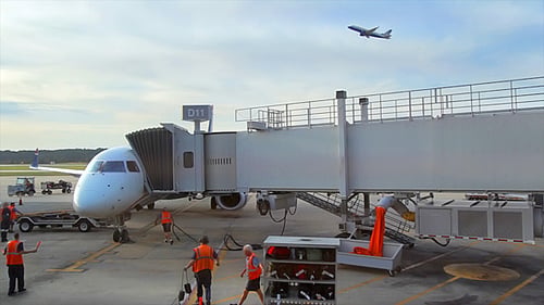 Passenger Airplane at Airport Terminal with Ground Crew