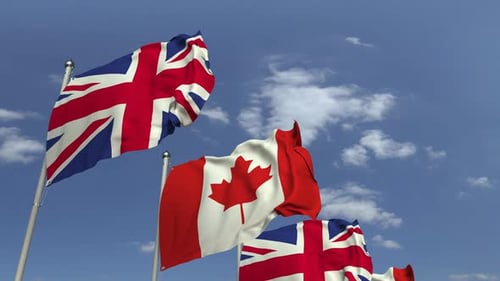 Realistic Waving Flags of Canada and United Kingdom Against Blue Sky