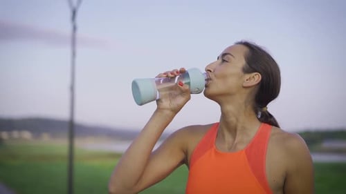 Woman Drinking Water During Fitness Workout