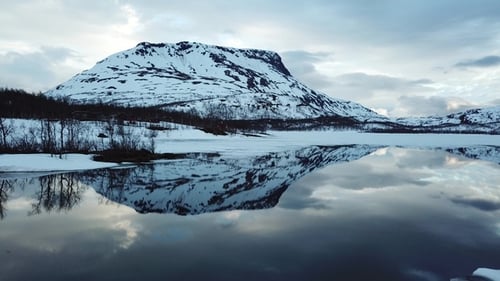 Reflection of mountains in the water of the Norwegian fjord. Lofoten islands, Norway - aerial shot.