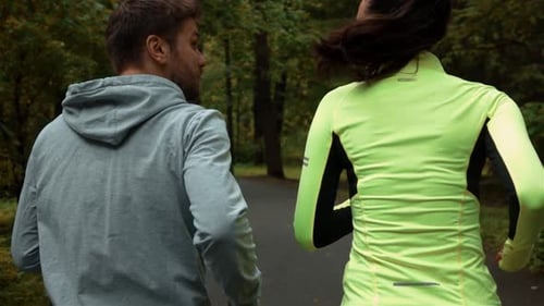 Woman and Man Communicating and Smiling During Morning Jog. They Running at the Park