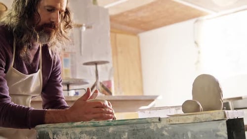 Man Working with Clay at Pottery Wheel