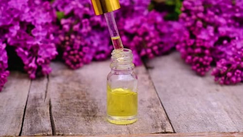 Dropper Adding Liquid to Bottle with Flowers