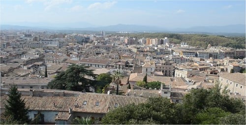 Cityscape Panorama with Tile Roofs and Distant Mountains