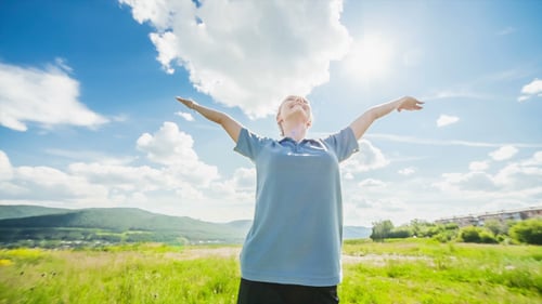 Young Woman Enjoying Freedom in Nature on Hilltop