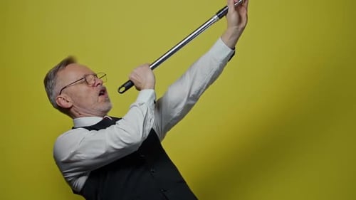 Man Singing into Tube on Yellow Background