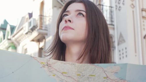 Young Woman Reading Map in City