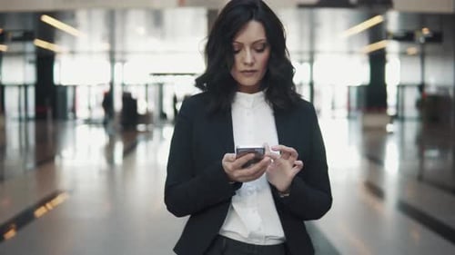 Woman in a Business Suit Walks Through the Lobby of a Modern Office Building