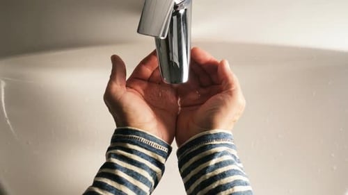 Hands under Faucet with Flowing Water