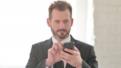 Man Celebrates Success Looking at his Phone