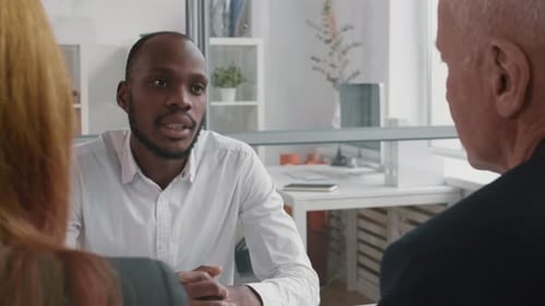 Afrikanischer Mann im Gespräch mit unkenntlichen Kollegen