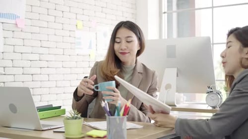 Two young Asian businesswomen working together in office.