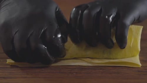Hands of the Skill Chef in schwarzen Gummihandschuhen zur Herstellung von Shawarma