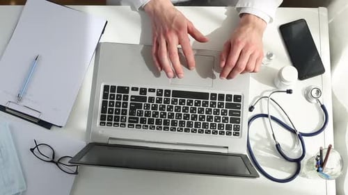 Doctor works on a laptop. top view.
