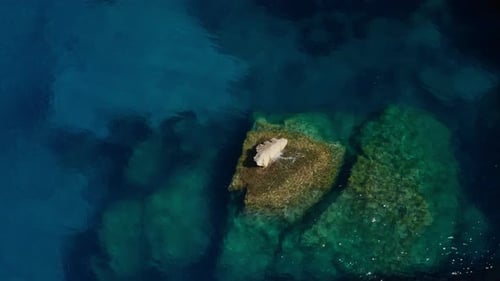 Drone Of Rock Balanced Above Water In Turquoise Sea