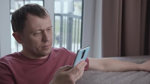 Man Using Mobile Phone in an Indoor Home Setting