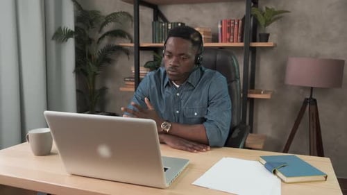 African Man, Call Center Agent in Headset Consult Business Client Online Using Laptop, Black