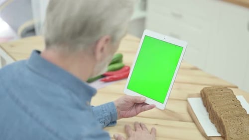 Rear View of Old Man Looking at Tablet with Chroma Key Screen