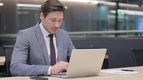 Middle Aged Businessman with Laptop, Thinking in Office