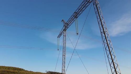 Metal Electricity Pylons in Rural Setting Against Blue Sky