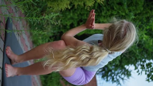 Woman Trains on the Street in the Evening Does Yoga Vertical View