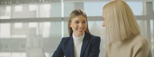 Two Young Women Talking in Modern Office