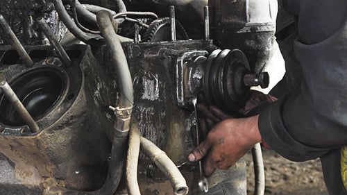 Man Repairing Greasy Truck Engine Close Up