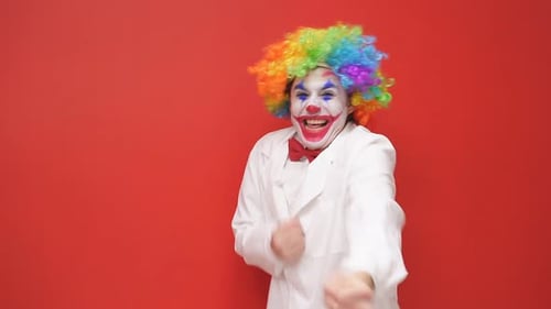 Smiling Clown Mimes Pulling a Rope on Red Backdrop