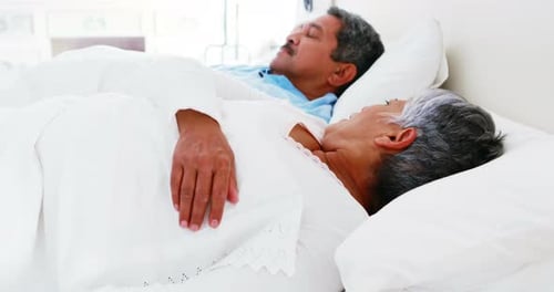 Femme âgée dérangée par le ronflement d'un homme sur le lit 4k