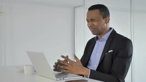 Frustrated Man in Suit Using Laptop at Desk